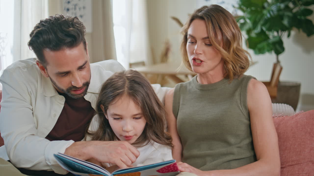 Primo piano di una famiglia positiva che legge un romanzo e trascorre del tempo a casa. Ragazza che si gode un libro