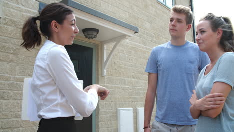 young couple viewing a house with female real estate agent