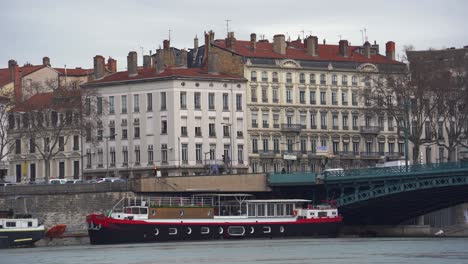 lyon's charms: classic architecture, iron bridge, and cruise ship along the rhone river, inviting a scenic tour through the city's waterways