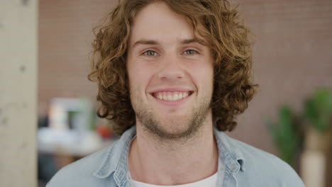 young caucasian man smiling portrait happy enjoying success satisfaction looking at camera cheerful friendly student in office workspace