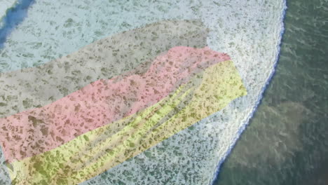 animation of flag of germany blowing over aerial view of waves in sea