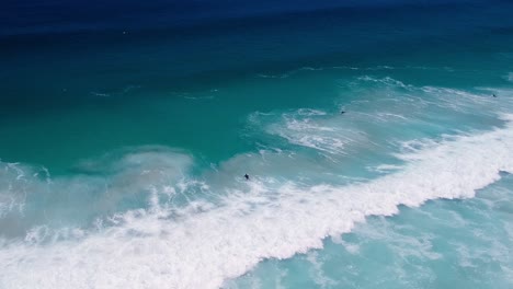 衝浪者<unk>在波浪下潛水,遠處的無人機射擊