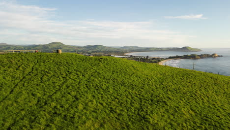 Karitane-Beach-and-bay-in-Karitane-area,-New-Zealand,-aerial-rise-up-shot