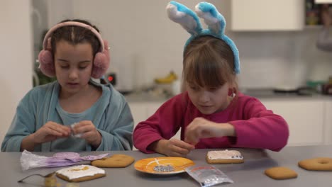 two cute sisters make and decorate cookies