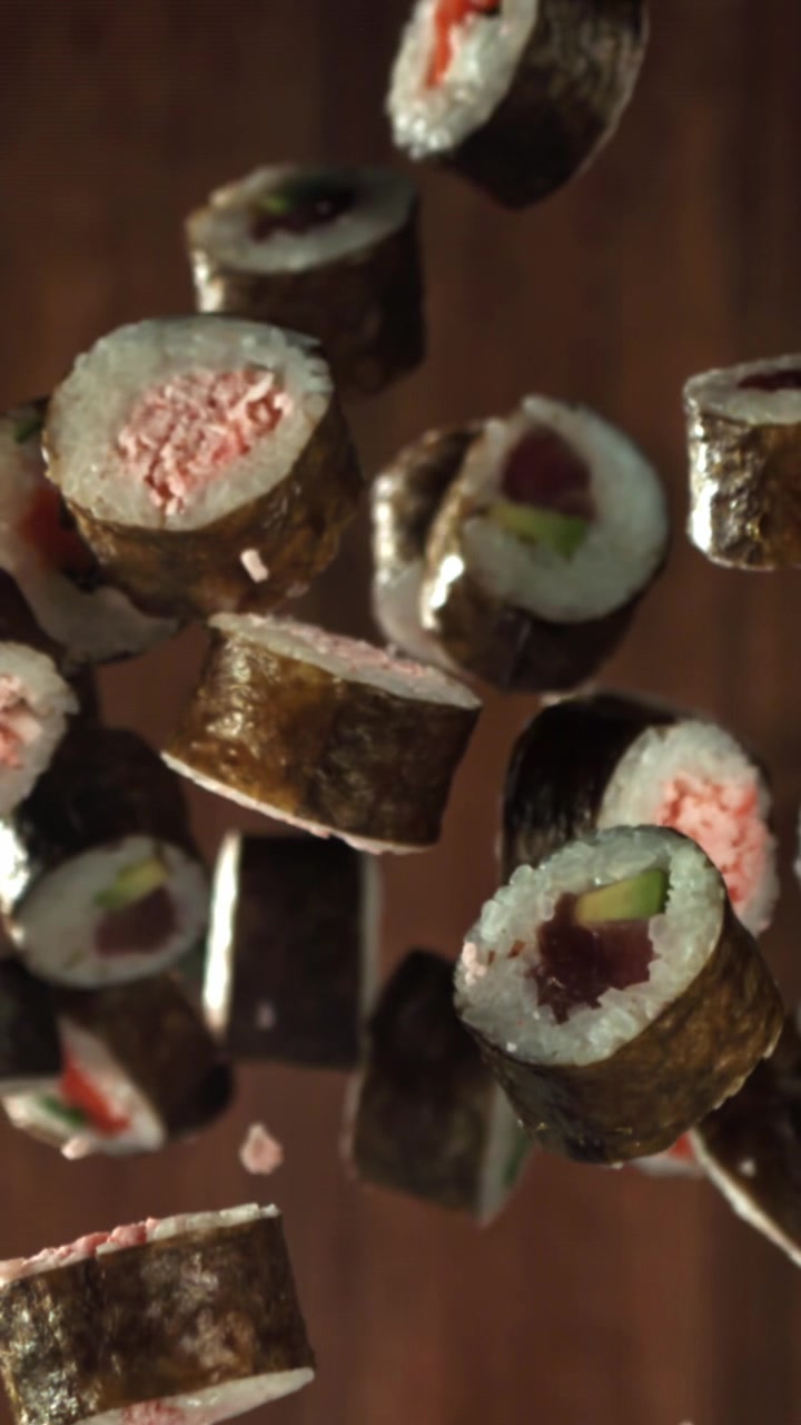 Roll di sushi assortiti che cadono in movimento rallentato