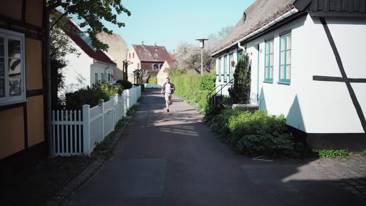 Bearded man running towards camera in colorful shirt in the streets of copenhagen