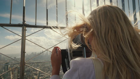 a woman looks at a beautiful view of new york from the observation deck the wind plays with her hair