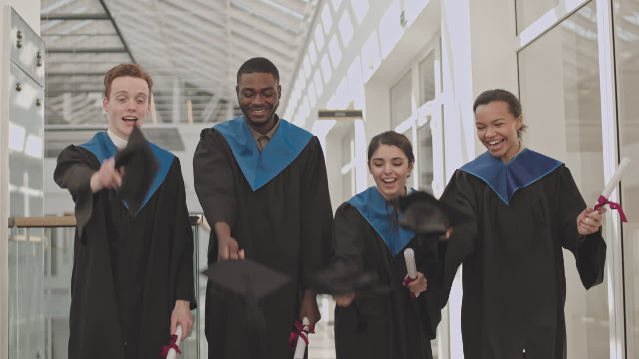 Cheerful Graduates Tossing Hats Up