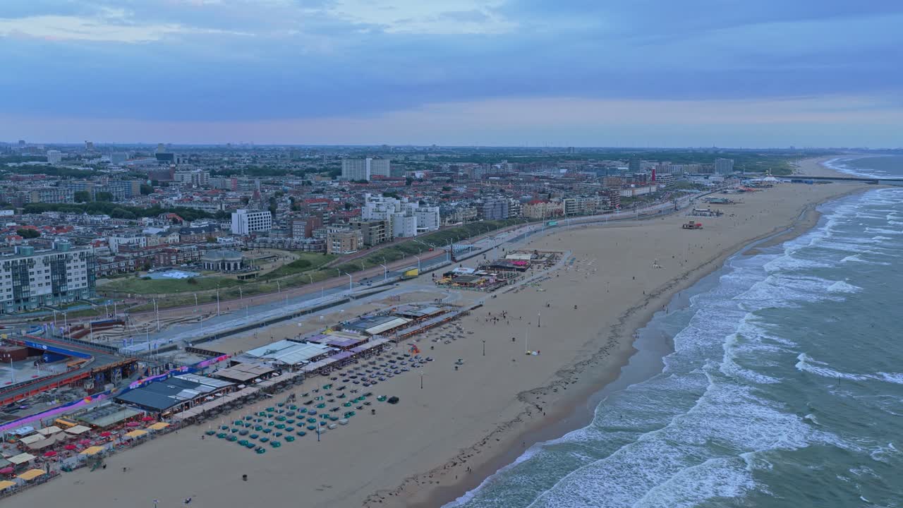Luftpanorama av Scheveningen strand og byens silhuett ved solnedgang, Nederland