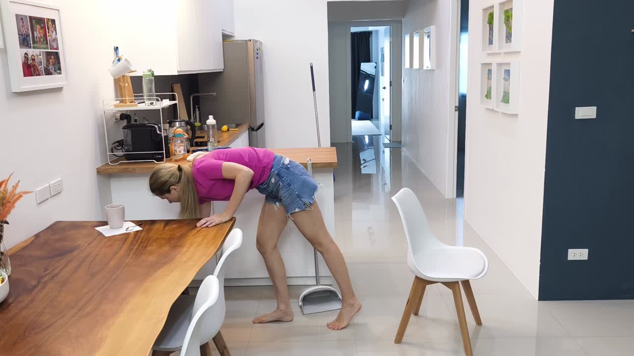 mujer limpiando una cocina de casa moderna y área de comedor