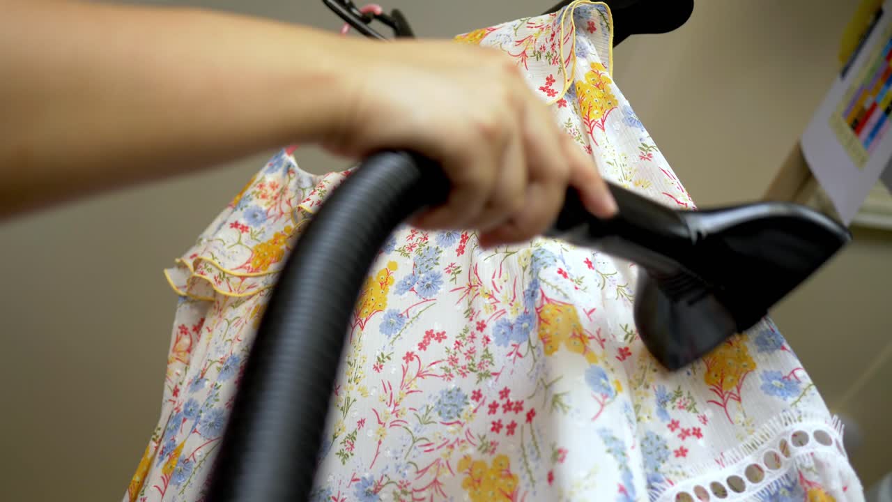 Closeup of a woman ironing clothing by stream iron on board at home with slow motion scene