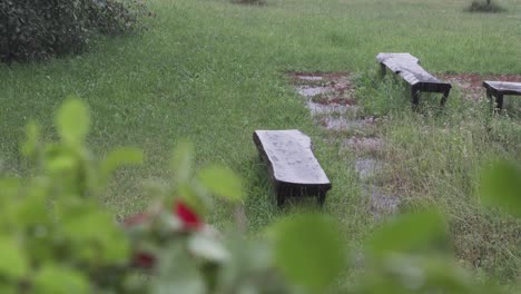 Heavy-raining-on-garden-bench,-moody-and-melancholic-feeling