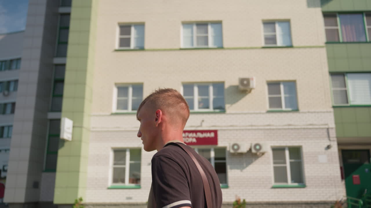 Individual Cautiously Passes Medical Center Building, Person With Health Concerns Avoids Crossing Clinic Entrance, Man Exhibits Anxious Hesitation While Walking Past Health Clinic And Signage