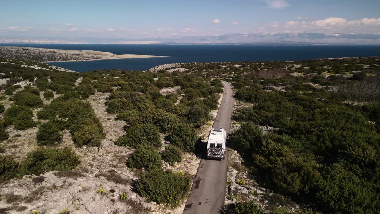 녹색 산 4k를 통과하는 크로아티아 해안으로가는 길에 자전거가있는 밴 뒤에서 똑바로 공기를 마시십시오.