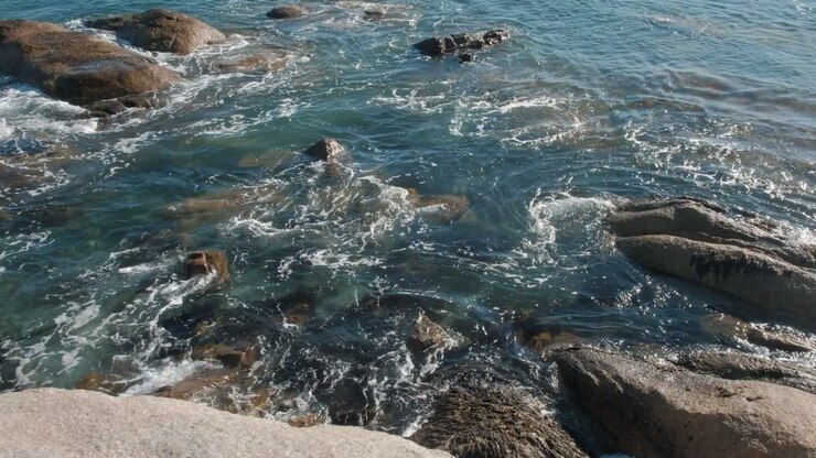 Ripresa aerea di onde oceaniche che scorrono sulle rocce