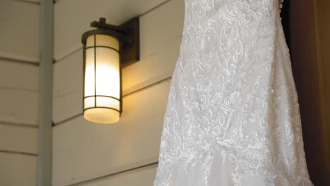 Beautiful-close-up-of-a-wedding-gown-hanging-from-the-arched-wooden-doorway-of-the-guest-house-at-Le-Belvédère-in-Wakefield,-Quebec,-Canada