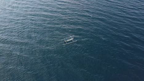 aerial circling view of a small boat sailing in the blue ocean on summer