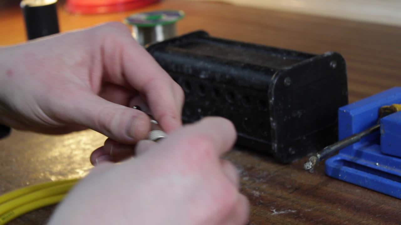 Audio music cable manufacturing soldering. Instrument and microphone lead is prepared with wire strippers before solder is applied.