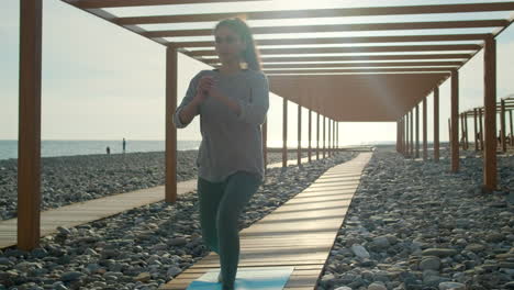 mujer haciendo ejercicio en una pasarela de la playa
