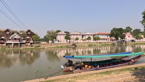 a long boat moves steadily on a tranquil river.