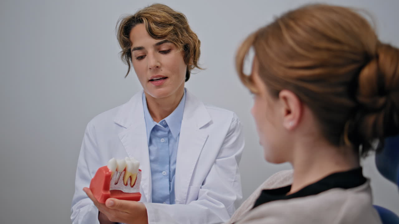 Professional stomatologist consulting patient in clinic closeup. Woman dentist