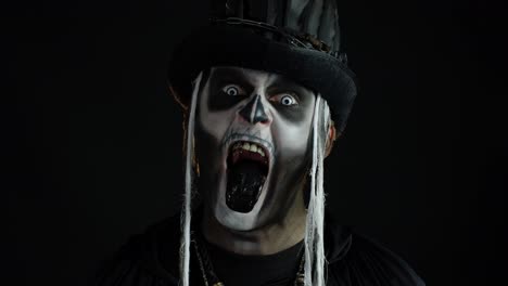 Man-in-skeleton-Halloween-costume-opening-his-mouth,-showing-black-tongue,-dirty-teeth,-scaring-you