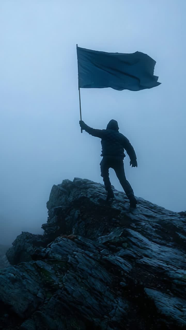 A determined figure stands atop a rugged mountain peak, proudly holding a flag, embodying resilience and triumph against a backdrop of fog and mystery