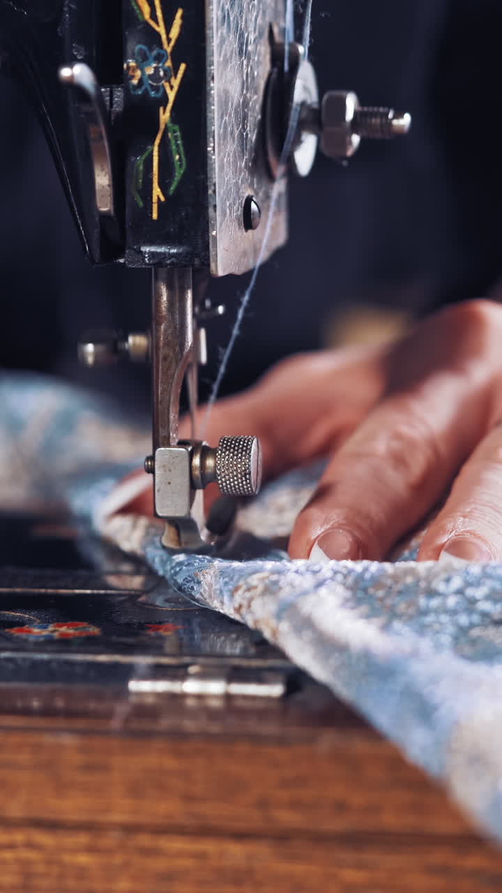 Woman hands behind sewing. Seamstress woman sewing clothes with sewing machine Vertical video