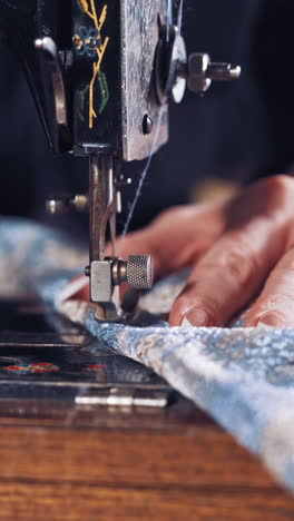 woman hands behind sewing. seamstress woman sewing clothes with sewing machine vertical video