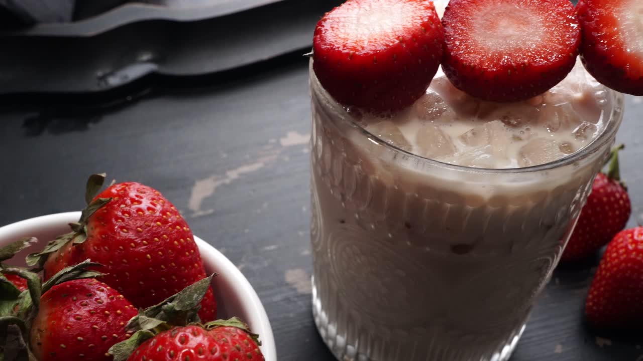 Pink cocktail drink with strawberry liqueur, vanilla vodka and cream. Party drink with strawberries. Fruit cocktail with fresh strawberries as a garnish. Cold and refreshing