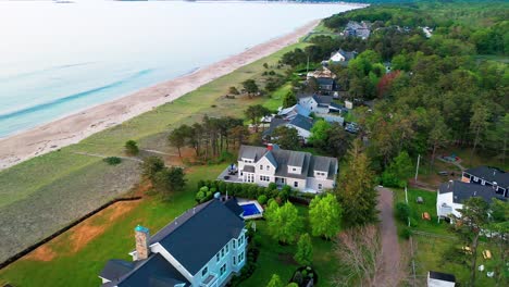 aerial drone footage of a scenic maine cottage. beach house with ocean views, patio, yard, and big windows overlooking the atlantic. prime coastal real estate for family holidays or retirement.
