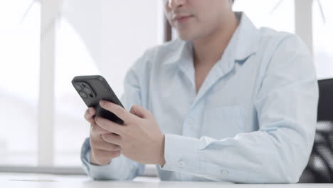 a male individual is doing an online transaction using his mobile phone and credit card.
