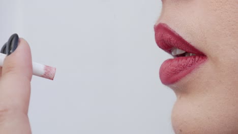 close-up profile view of a beautiful woman's lips as she smokes a cigarette