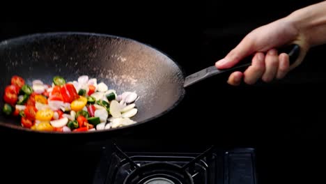 Slow-Motion-of-Chopped-Chili-and-Onion-Tossing-Up-With-a-Cooking-Pan-With-Black-Backdrop