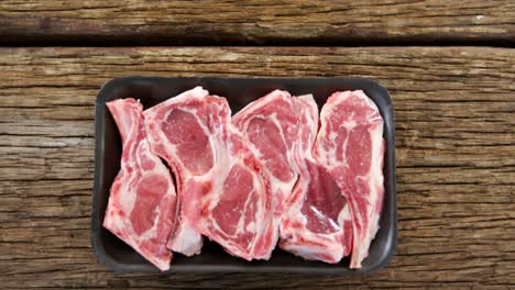 bistec de filete en un recipiente negro sobre un fondo de madera