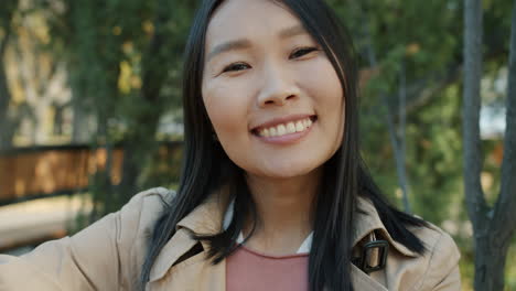 smiling asian woman in a park