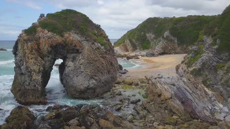 elephant rocks on the australian coast, an iconic sea stack on the rocky beach during day with waves crashing under windy weather