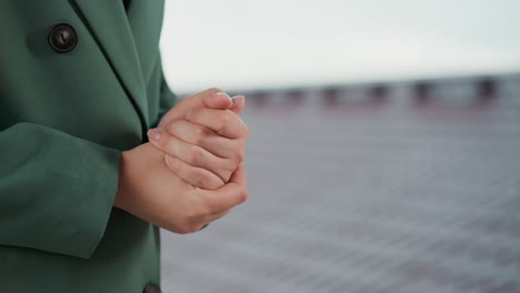 nervous woman rubs hands on roof closeup. businessperson worried by stressful situation at workplace on rooftop. lady scared by career obstacles