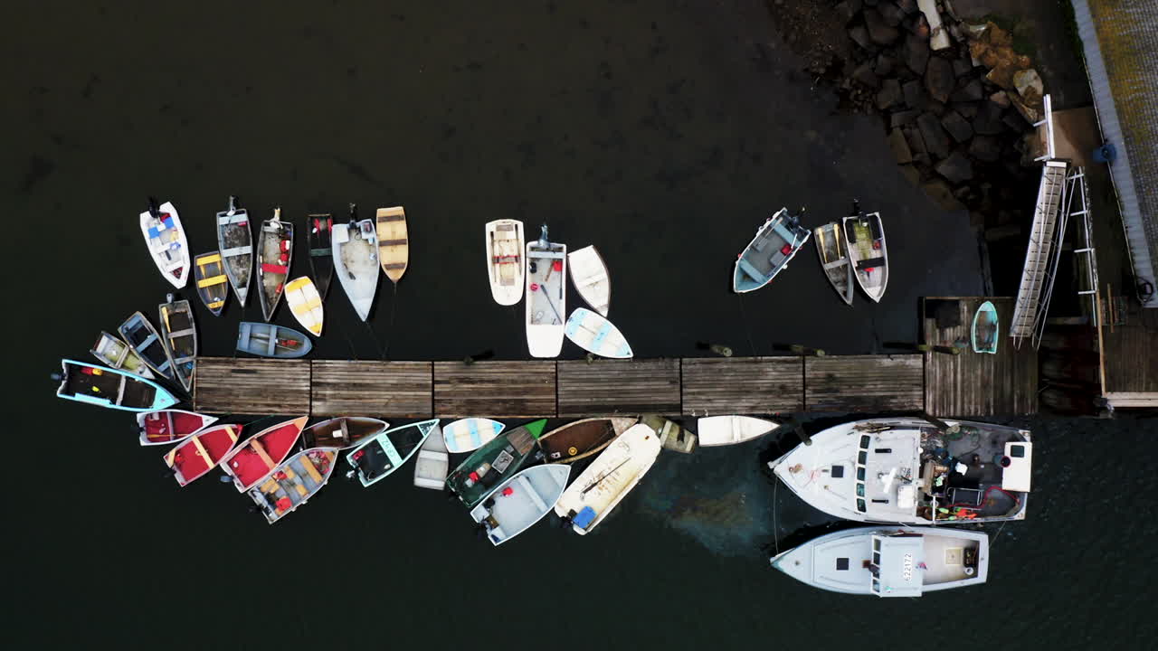 Droneskud af dokker med små både og hummerfiskerbåd, der lækker olie i havet, HD 30p.