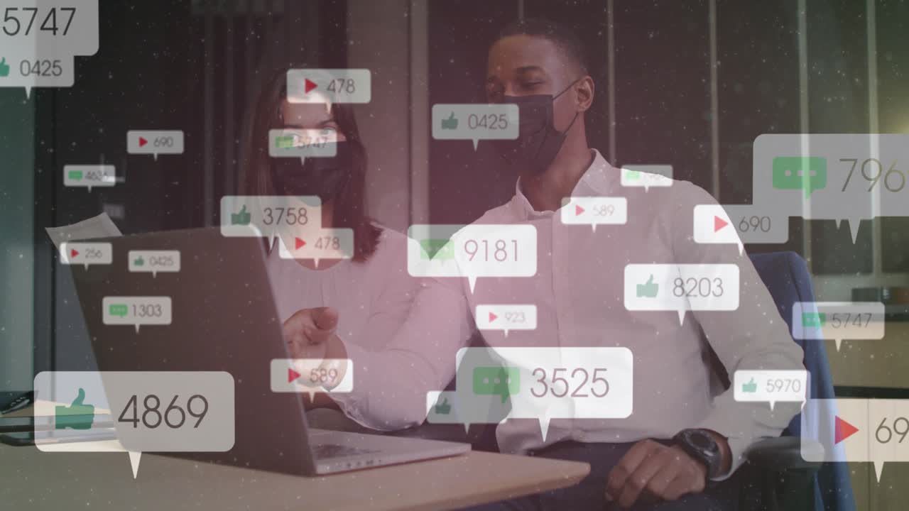 Colleagues reviewing social media, man holding phone starting overlay bubbles, woman tapping laptop