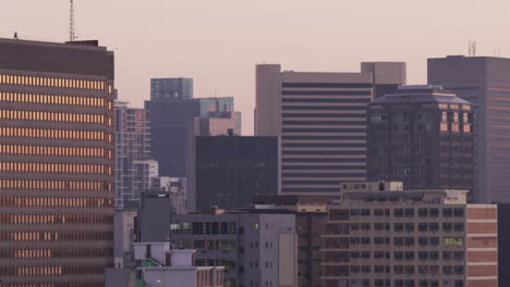 animation of squares around circle over aerial view of modern cityscape against sky