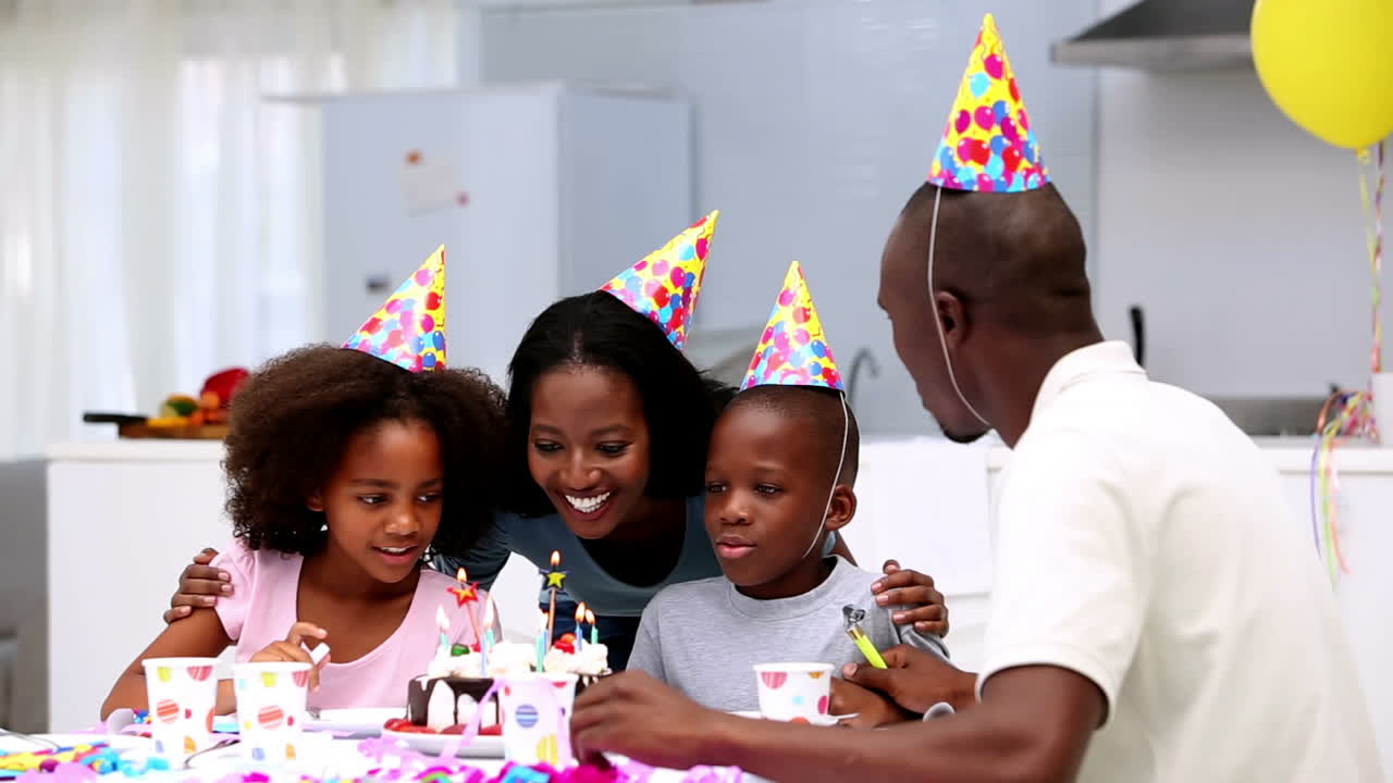 Son blowing out the candles on birthday cake