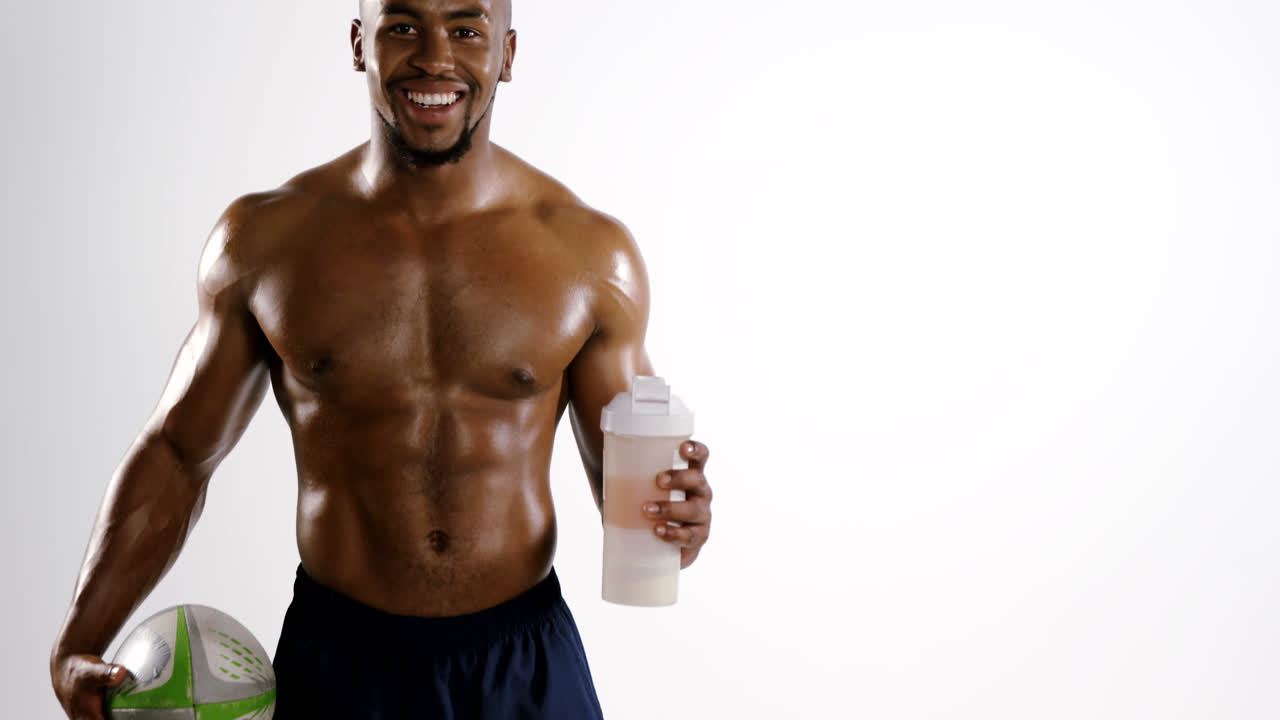 jugador de fútbol americano sosteniendo una botella de agua y una pelota de rugby