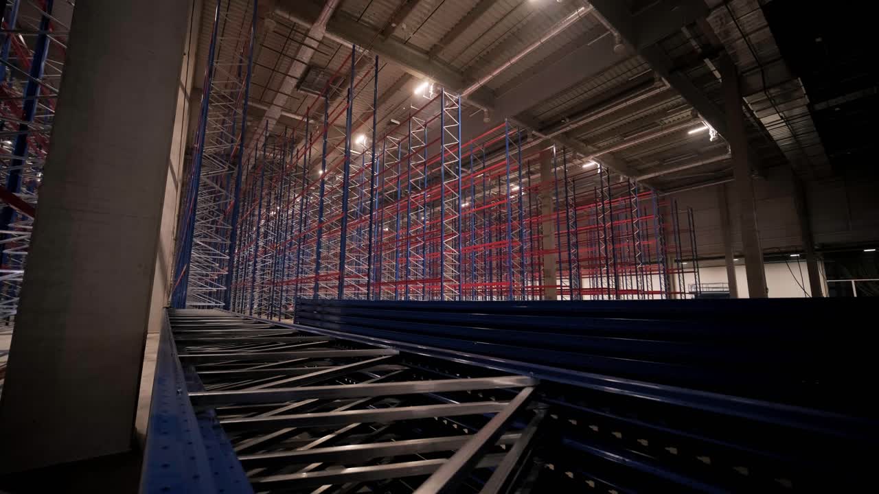 gran y moderno almacén en construcción, con estanterías metálicas y otros equipos industriales.