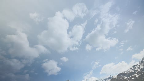 Mont-Cenis,-Francia,-Que-Muestra-Un-Paisaje-Montañoso-Sereno-Con-Picos-Nevados,-Un-Lago-Turquesa-Y-Terreno-Rocoso-Bajo-Un-Cielo-Parcialmente-Nublado