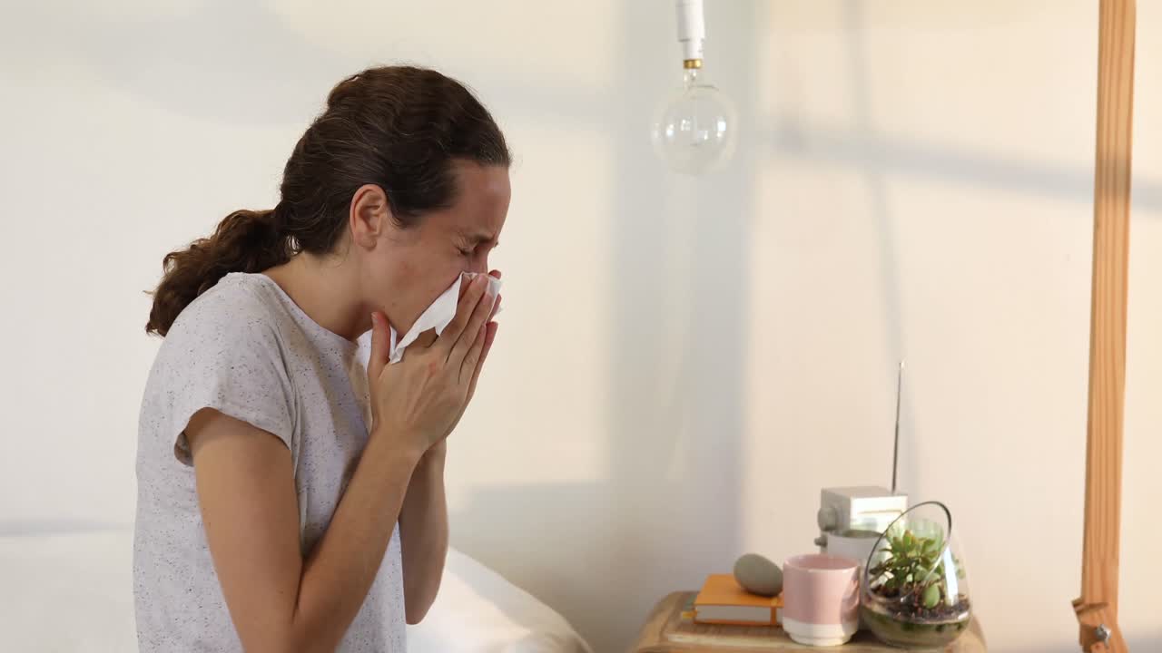 mujer caucásica enferma estornudando en casa