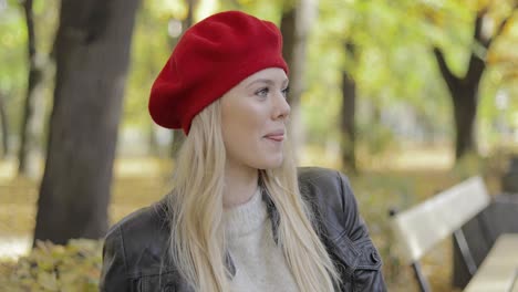 woman in red beret sitting on bench