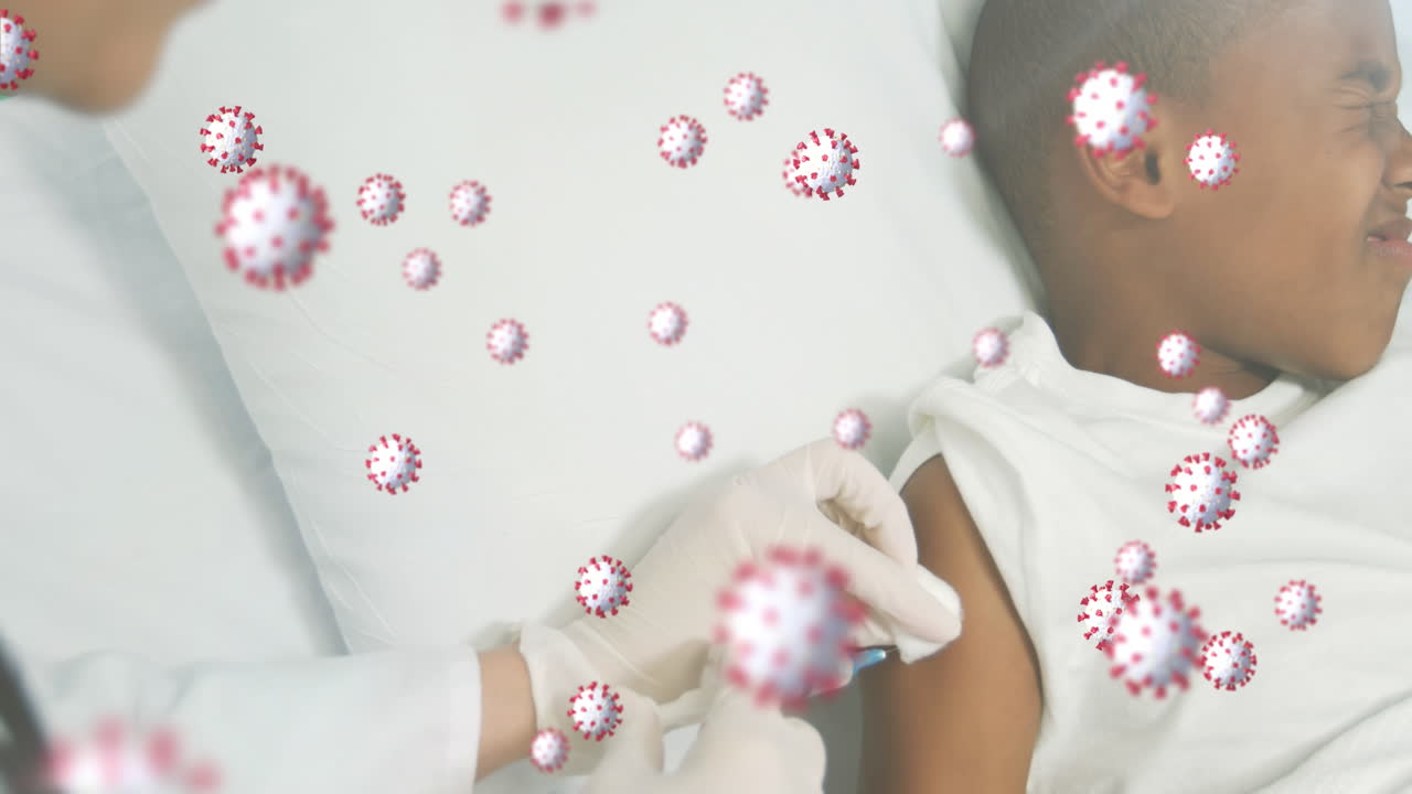 Covid-19 cells floating against doctor giving an injection to african american boy at hospital