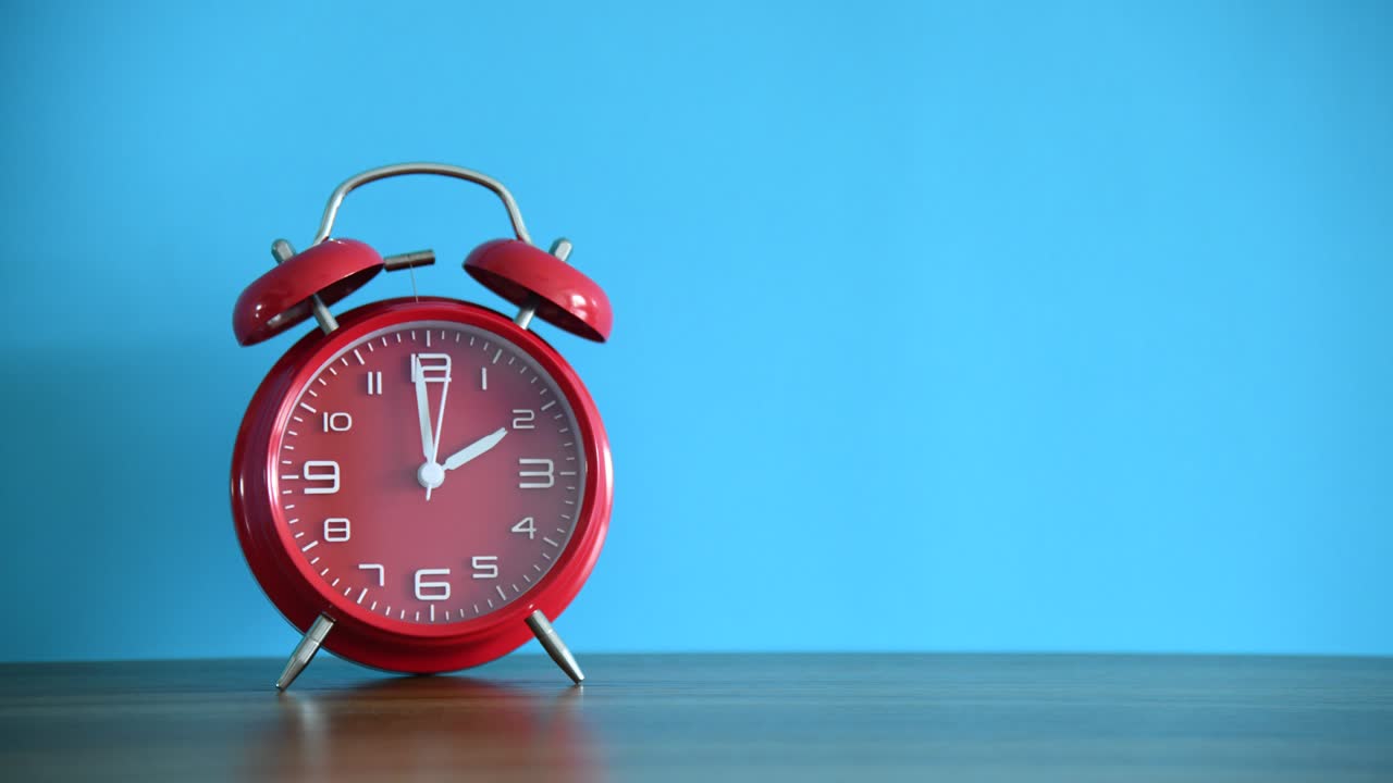 나무 테이블 에 있는 빨간 알람 시계 의 시간 지연