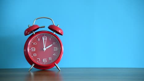 tiempo de lapse del despertador rojo en la mesa de madera